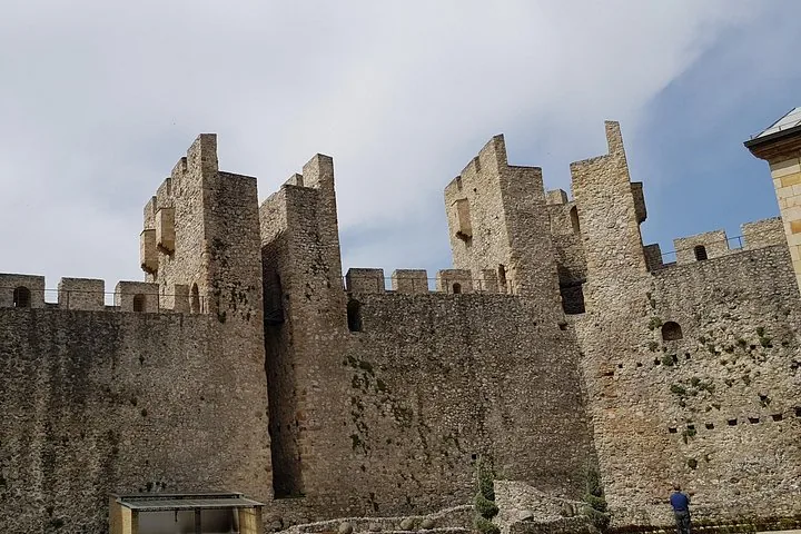 Altos muros de piedra almenados y torres de una fortaleza medieval