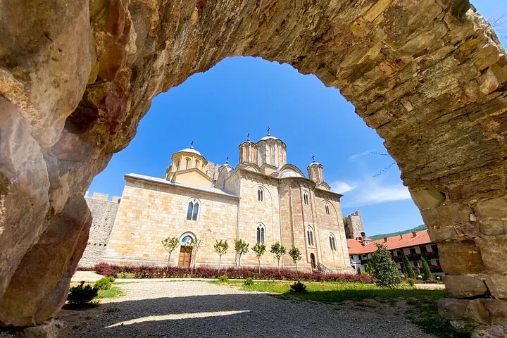 Manasija Monastery viewed through a stone archway on a clear day